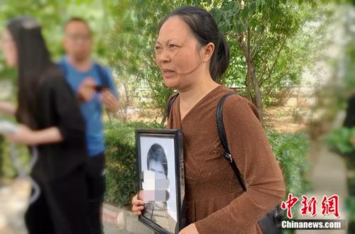 謝雕母親帶著謝雕的遺照走出法院 <a target='_blank' >中新網</a> 楊雨奇 攝 點擊進入下一頁